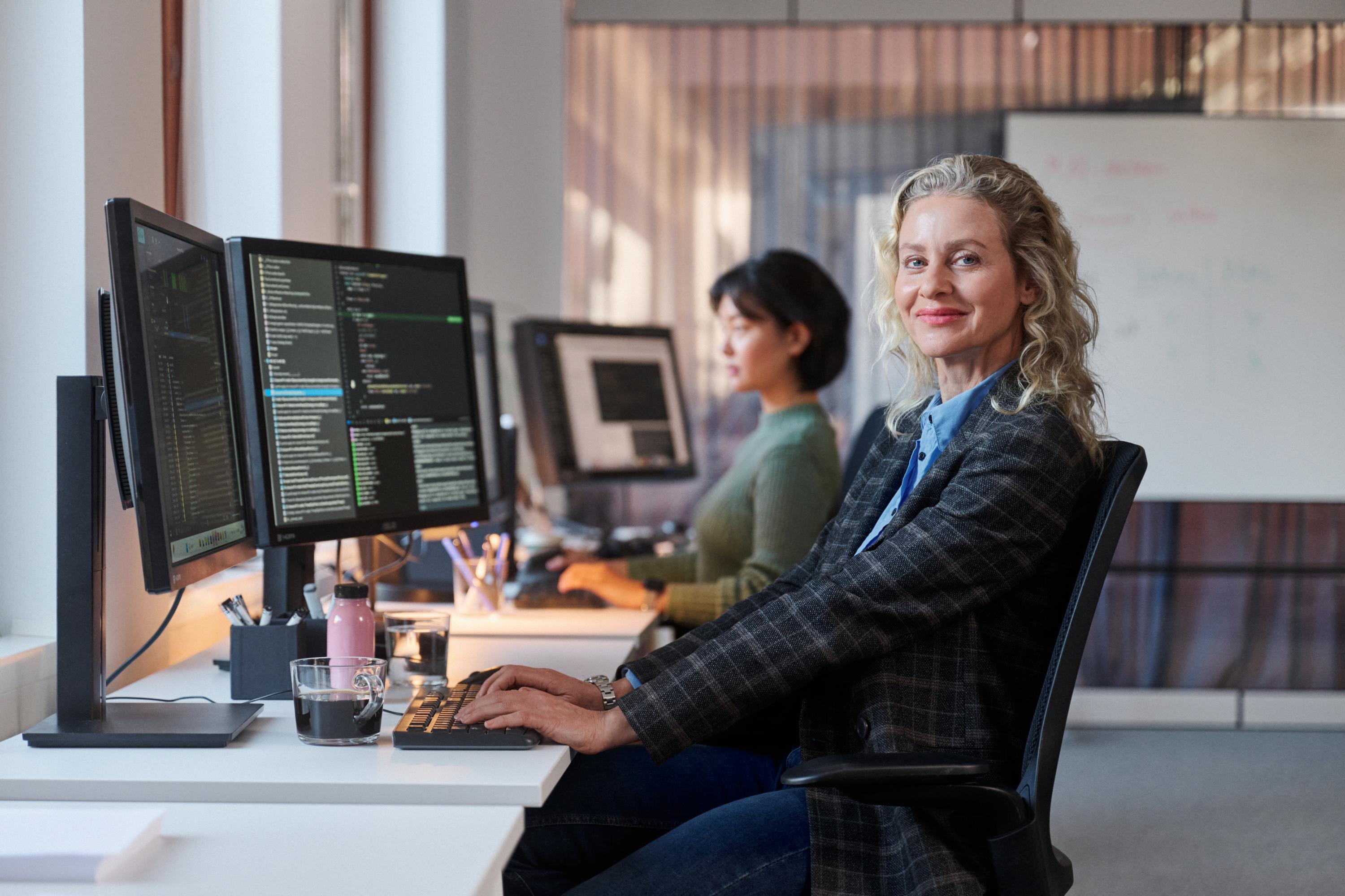 Två kvinnor på en arbetsplats arbetar med programmering